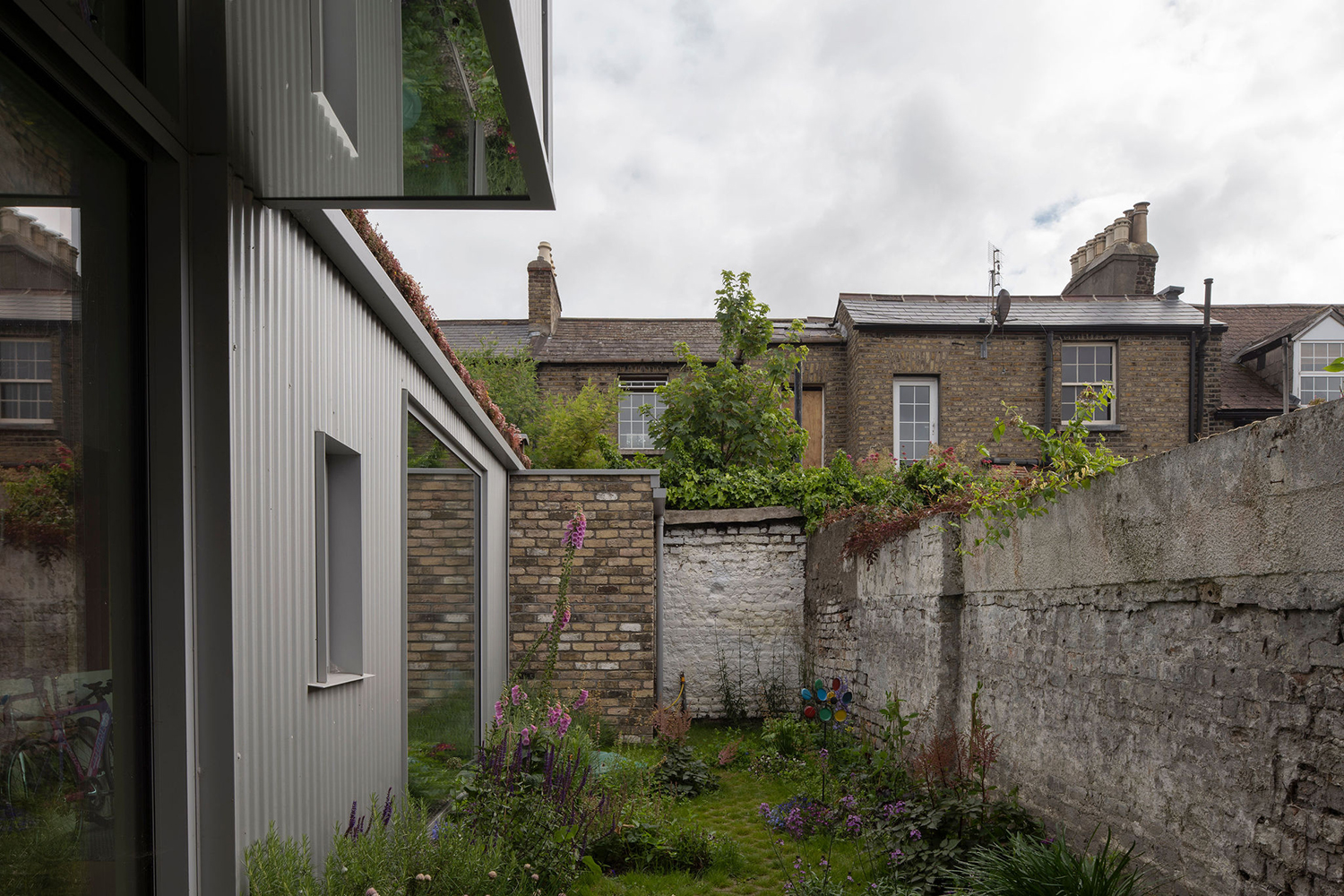 Garden area of house with stone walls with neighbourhood houses in the backgroung