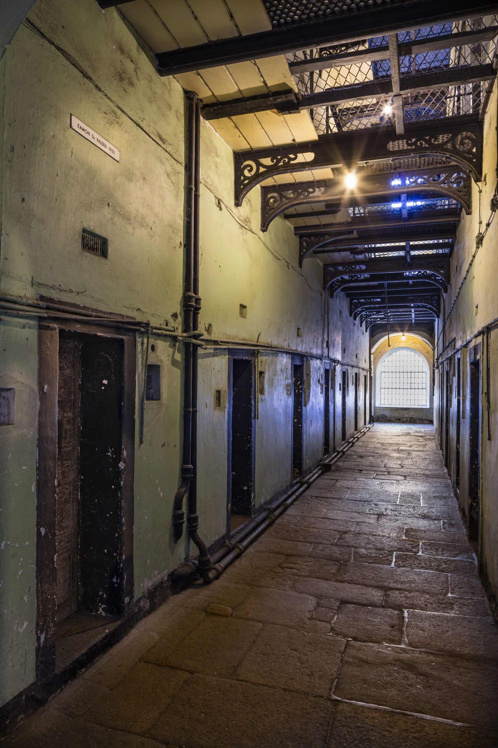 Interior of prison building displaying corridor with cell doors