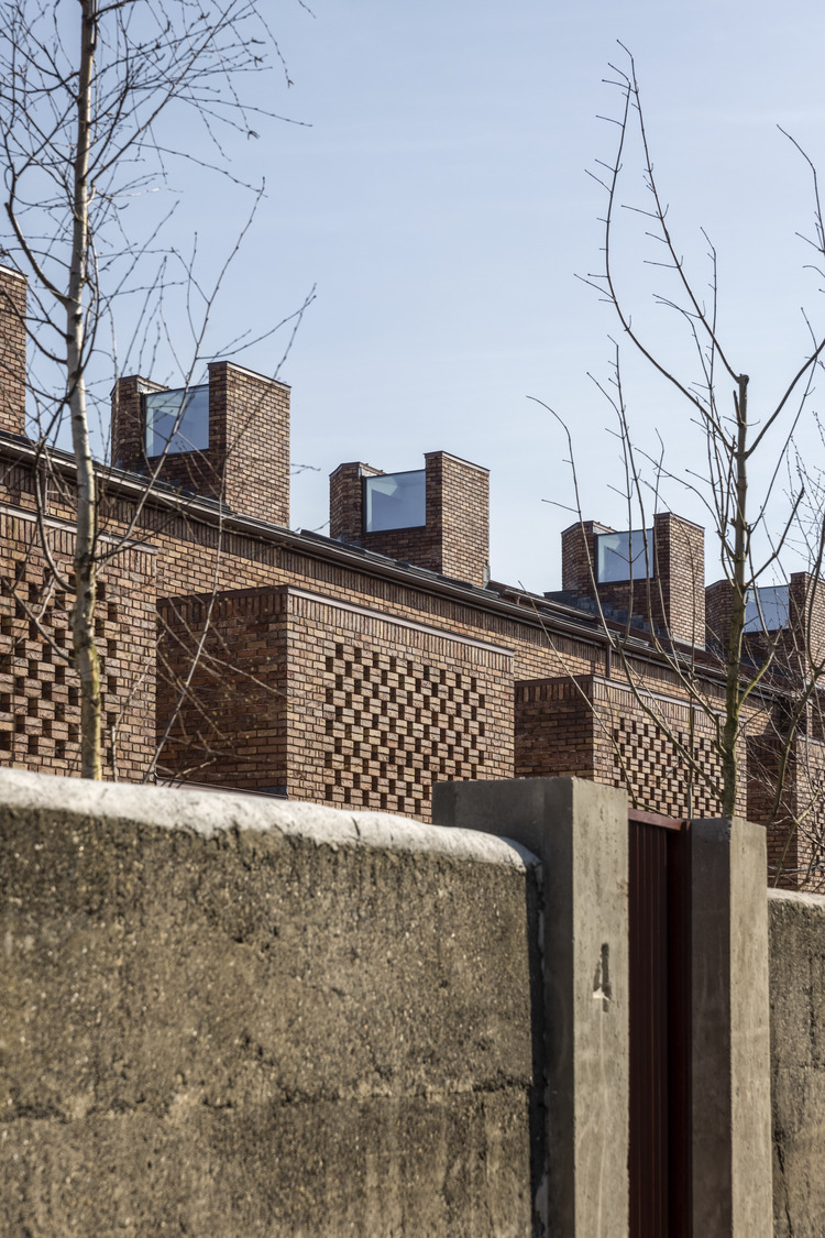 View of terracefrom backlane. The light well is featured as well as perforated brick, which conceals a private terrace
