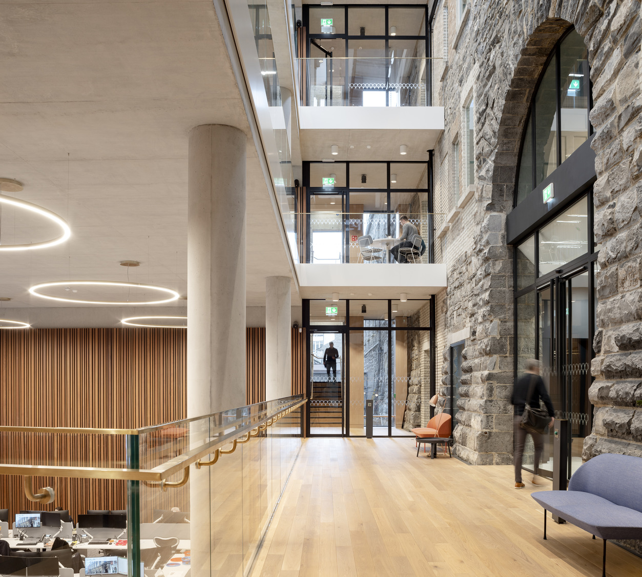 A triple-height-atrium stitches together a new and open staircase where staff can meet with an existing ceremonial staircase and creates a new east-west route that winds around the original and restored banking hall.