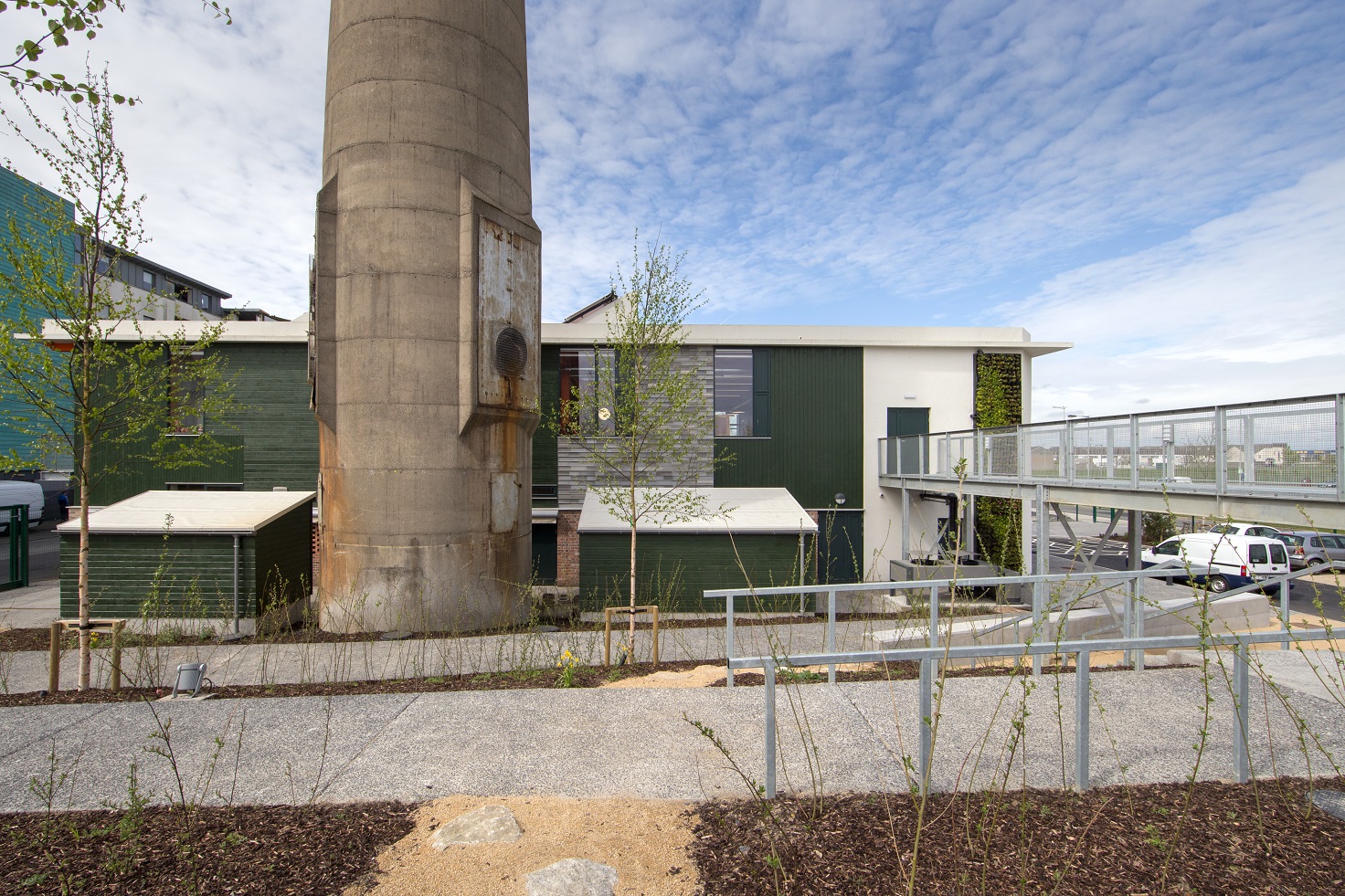 Exterior of building with green walls and tower on the foreground