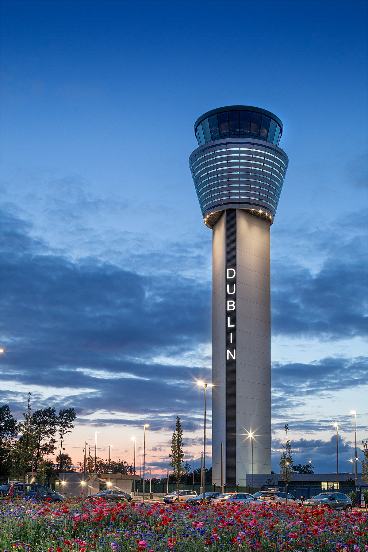Dublin Air Traffic Control Tower against blue dusk sky with red poppies in foreground