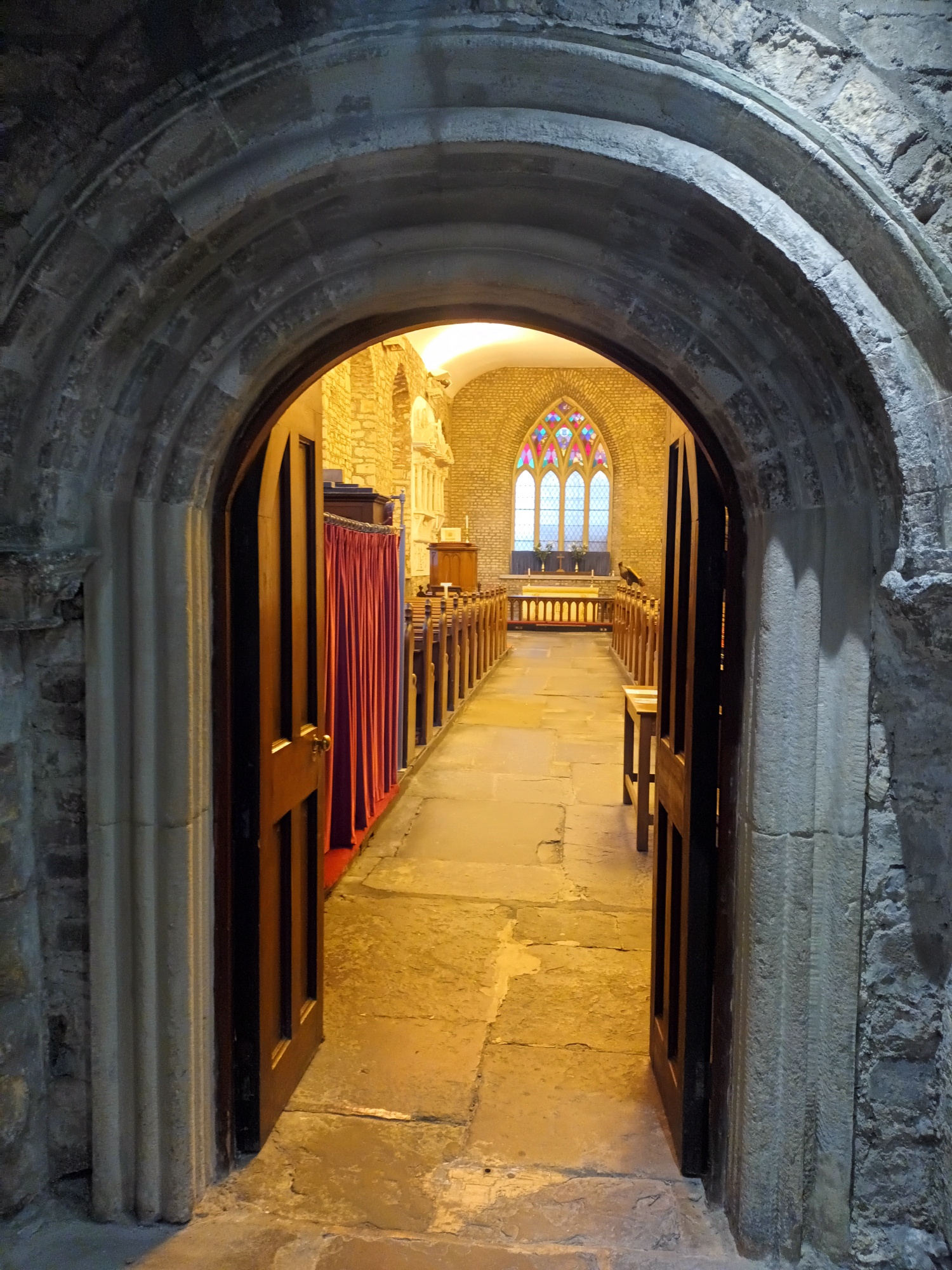 A view of the church from the porch and through the original dundry stone romanesque arch that would have been located on the original 12th century structure.