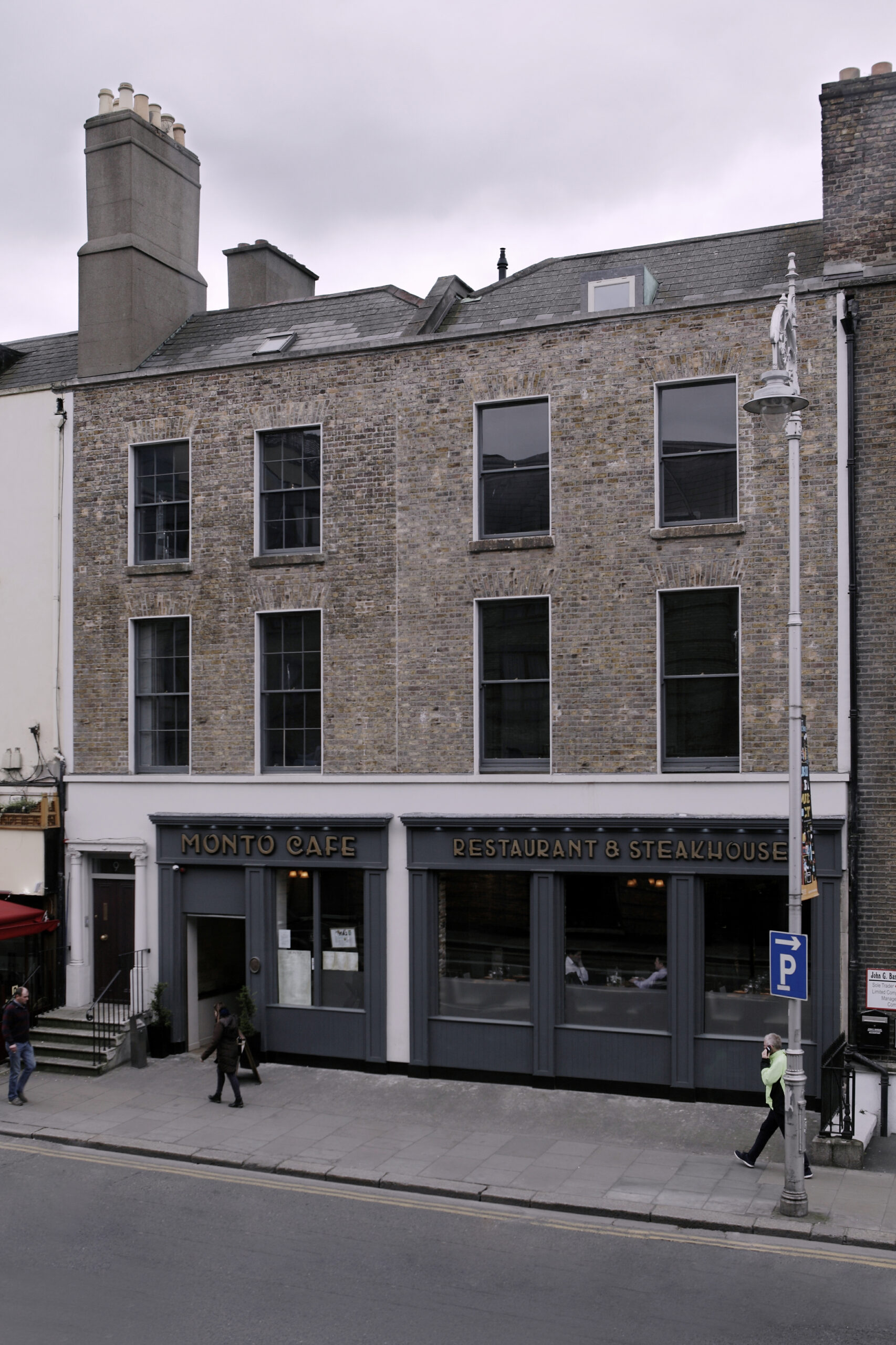 Street view of three storey building with pub on the ground floor.
