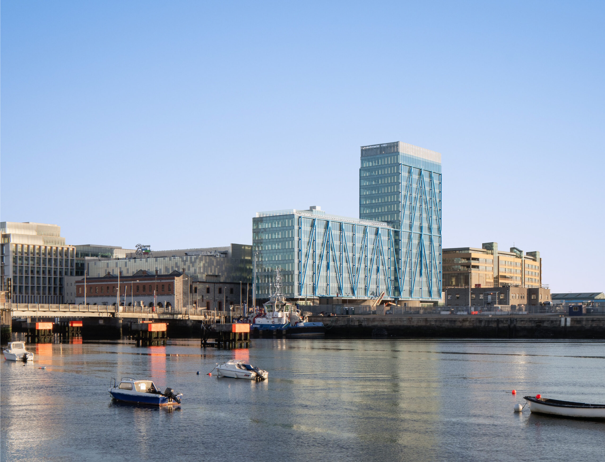View of tall building with glass and metal exterior from across River Liffey