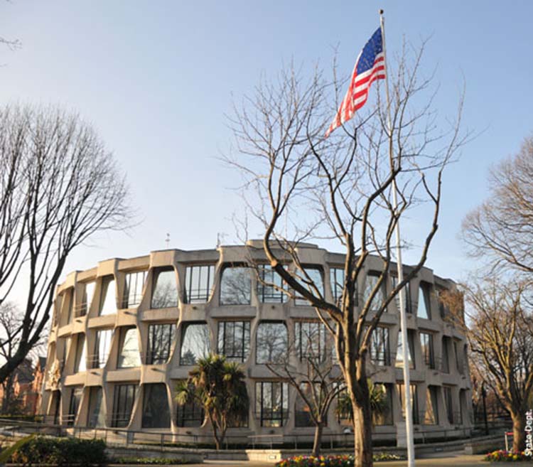 Outside view of circular concrete building with the US flag on the foreground
