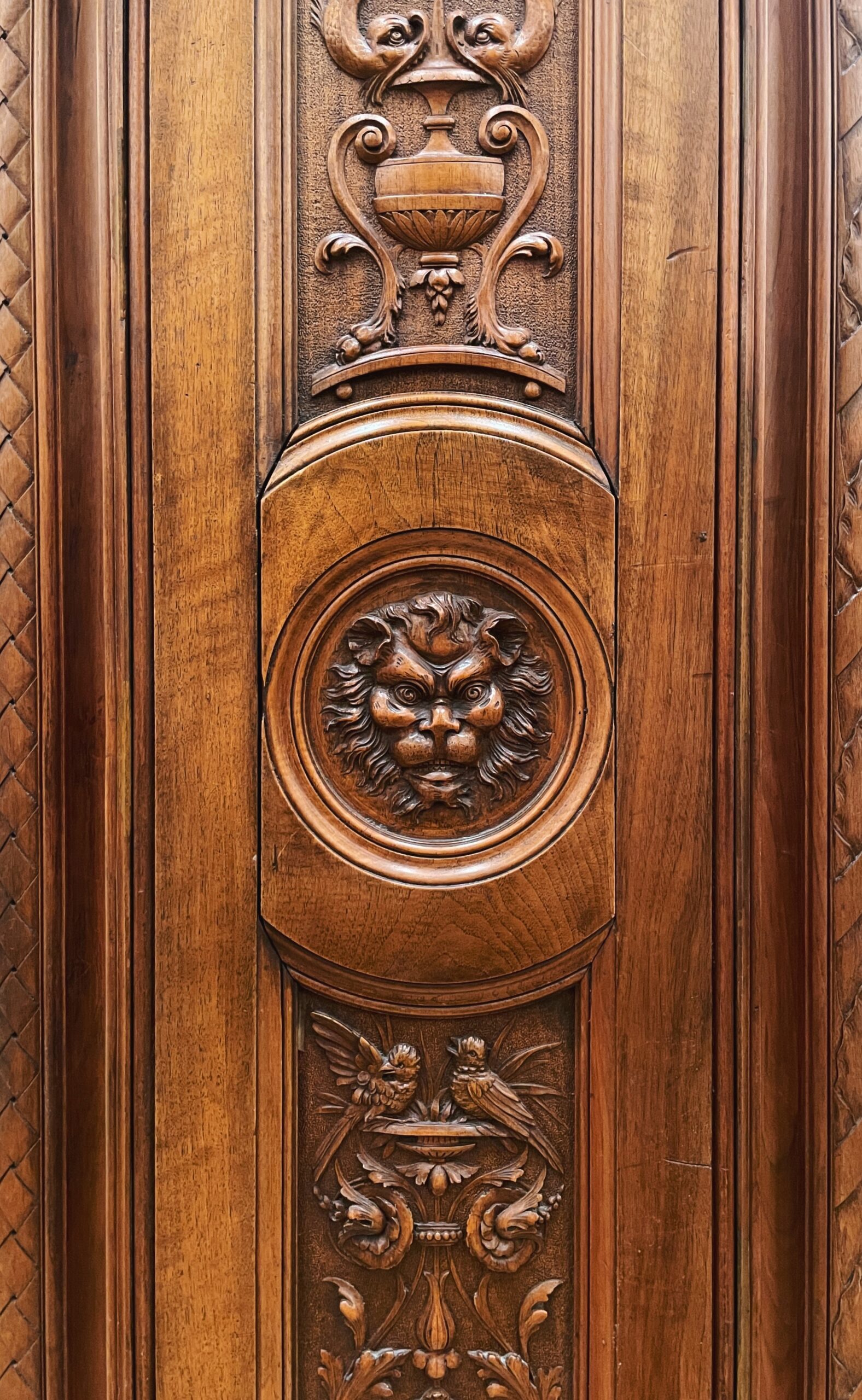 Carved doorway with a lion in the center surrounded by decorative detail